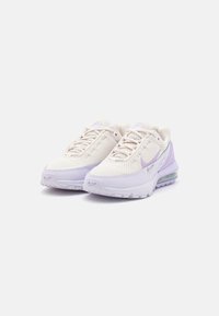 Lightweight sneakers with a mesh upper in cream, accented by light purple details. Features a cushioned sole and prominent Nike logo.