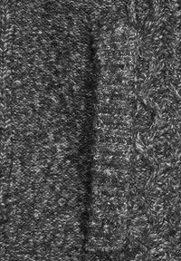 Chunkig grå stickad tyg med ett strukturerat mönster och kabelstickningselement. Materialet verkar mjukt och tätt med varierande nyanser av grått.