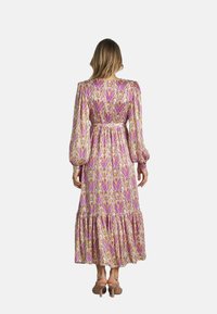 Langes, fließendes Kleid aus leichtem Stoff mit einem bunten Muster in Pink, Gelb und Violett. Puffärmel und gestufter Saum.