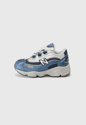 Blå og hvid New Balance 1000 sneaker med mesh paneler, tyk sål og snørelukning, vist i sidelæns profil på ensfarvet baggrund.