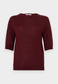 Burgundy lyhythihainen neule, jossa on pyöreä pääntie, valmistettu kevyestä kankaasta. Hihansuissa ja helmassa on ribbireunat.