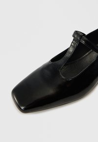 Černý kožený bota Mary Jane se čtvercovou špičkou, texturovaným povrchem a jedním popruhem nad klenbou, zdobený výřezy.