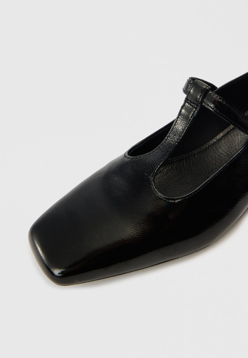 Schwarzer Mary-Jane-Schuh aus Leder mit quadratischer Spitze, strukturierter Oberfläche und einem einzelnen Riemen über dem Spann mit einem ausgeschnittenen Detail.