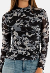 Top a maniche lunghe realizzato in tessuto trasparente con un motivo astratto nero e grigio. Ha un collo alto e una silhouette aderente.
