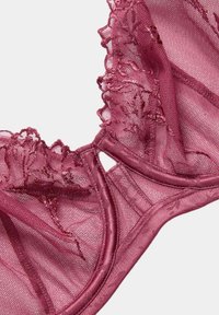 Reggiseno in pizzo malva con motivi floreali, tessuto in rete trasparente e bordi ondulati. Presenta spalline regolabili e un sottobanda morbido.
