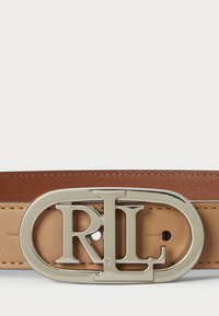 Béžový kožený opasok s leštenou striebornou oválnou prackou, na ktorej sú výrazne zobrazené písmená "RL". Hladký povrch s viditeľným šitím.