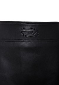 Zwarte leren laars met een gladde textuur, voorzien van een gedebosseerd logo op de bovenkant en een eenvoudig, klassiek ontwerp.