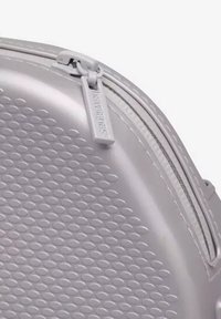 Borsa rigida argento con un motivo testurizzato di piccoli ovali in rilievo. Caratterizzata da una cerniera liscia con un pull tab personalizzato.