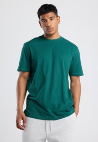 Green cotton T-shirt with a crew neckline and short sleeves, featuring a relaxed fit and smooth, even texture.