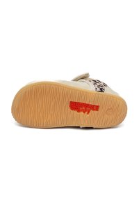 Buty zapinane na rzep, z górą z tanowego zamszu, akcentem z wzorzystej tkaniny oraz teksturowaną gumową podeszwą. Posiadają czerwone logo na podeszwie.