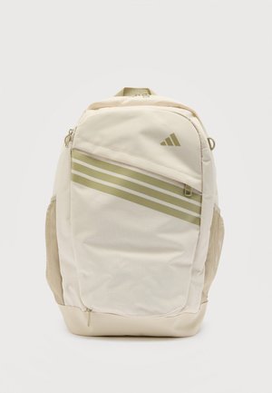 Bež nahrbtnik z diagonalnimi svetlo zelenimi črtami, sprednjim žepom z zadrgo, mrežastimi bočnimi žepi in zgornjim ročajem.