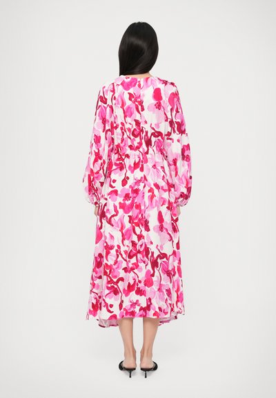 Rochie cu imprimeu floral, în nuanțe de roz, cu un design fluid, mâneci lungi și talie ajustată; material ușor, cu o textură moale.