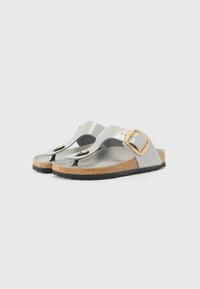 Silver metallic sandals with cork soles, featuring a toe loop and adjustable gold buckle hardware. Flat, textured tread for grip.