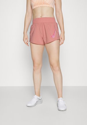 Vaaleanpunaiset urheilushortsit, joissa on joustava vyötärö. Sivussa valkoinen Nike Swoosh -logo. Sileä kangas, vartalonmyötäinen leikkaus, polven ylle ulottuva pituus.