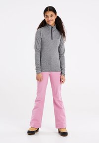 Grijze lange mouwen pullover met een halve rits kraag, gecombineerd met roze skibroek. De outfit heeft een gladde textuur en is ontworpen voor actieve kleding.