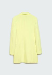 Gele blazer met een getailleerd ontwerp, lange mouwen en een enkele achtersplit. Gladde textuur en revers met inkeping.