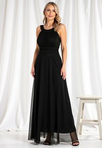 Czarna długa sukienka z dopasowanym topem, z marszczonym materiałem i szerokim dekoltem. Lekka, przezroczysta spódnica z jednolitą podszewką.