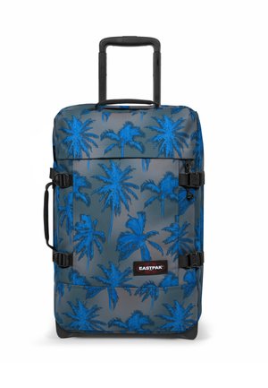 Maleta de ruedas con un patrón de palmeras azules sobre un fondo gris, equipada con un mango retráctil y hebillas laterales para un cierre seguro.