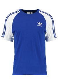 Sininen Adidas t-paita, jossa valkoiset raglan-hihat ja kolme sinistä raitaa hartioilla ja hihoissa. Paidassa on Adidas-logo rinnan kohdalla.