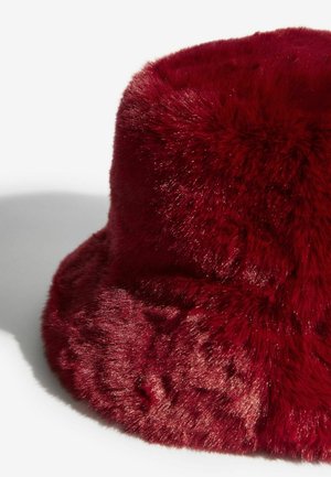 Červený klobúk z umelej kožušiny so.soft, textúrovaným povrchom; zaoblená vrchná časť a široký okraj vytvárajú nadýchaný vzhľad.