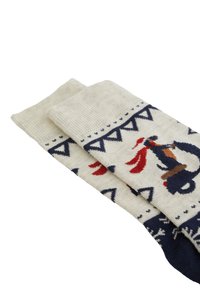 Stickade strumpor i krämfärg med marinblå och röda mönsterdetaljer. Har geometriska mönster och en lekfull djurgrafik nära kantlinjen.