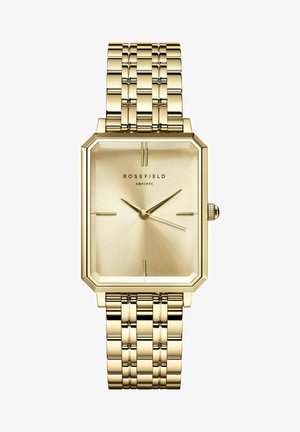 Montre en métal doré avec un boîtier octogonal, un cadran texturé doré et un bracelet en or à maillons entrelacés. Design minimaliste avec des aiguilles fines.