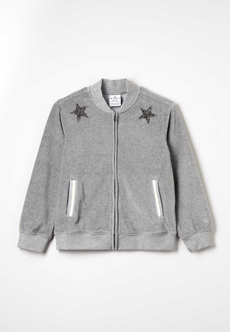 Felpa grigia con zip realizzata in tessuto morbido, con applicazioni a forma di stella sulle spalle e due tasche con zip bianche. Polsini e orlo a costine.