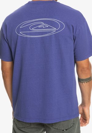 Lila Baumwoll-T-Shirt mit einem weißen runden Logo auf der Rückseite, kurzen Ärmeln und einem lockeren Schnitt. Glatte Textur mit Rundhalsausschnitt.