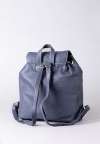 Navy leather backpack with a fold-over top, adjustable straps, and a loop handle. Features gold-tone hardware and visible stitch detailing.