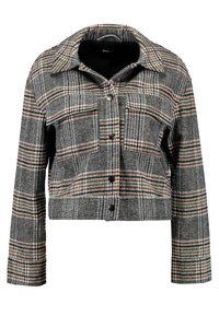 Szary marynarka w kratę z kołnierzowym wzorem, z dwoma kieszeniami na piersi, zapięciem na guziki i krótkim krojem. Tkanina ma teksturowane wykończenie.