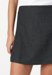 A dark gray denim mini skirt with a textured fabric, featuring a straight cut and hemline just above the thighs.