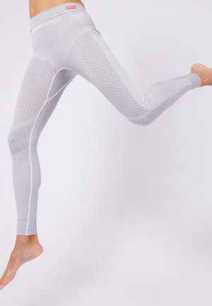 Leggings actifs gris avec un motif en maille texturée et des panneaux lisses, présentant un design ajusté et une coupe longueur cheville. Logo rouge au niveau de la taille.