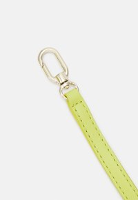 Cinturino in pelle verde brillante con dettagli di cucitura e un gancio a scatto in metallo argento per il fissaggio. Texture liscia e design elegante.