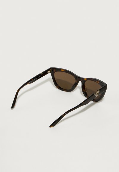 Ochelari de soare tortoise brown cu rame rotunde, lentile maro închise și accente aurii cu logo pe brațe. Textură din plastic neted.