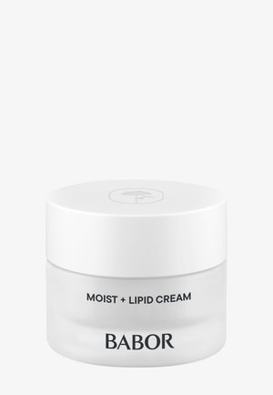 Le pot de Crème Hydratante + Lipides a une base en verre transparent et un couvercle blanc lisse, présentant un texte minimaliste en noir ; forme ronde avec une finition polie.