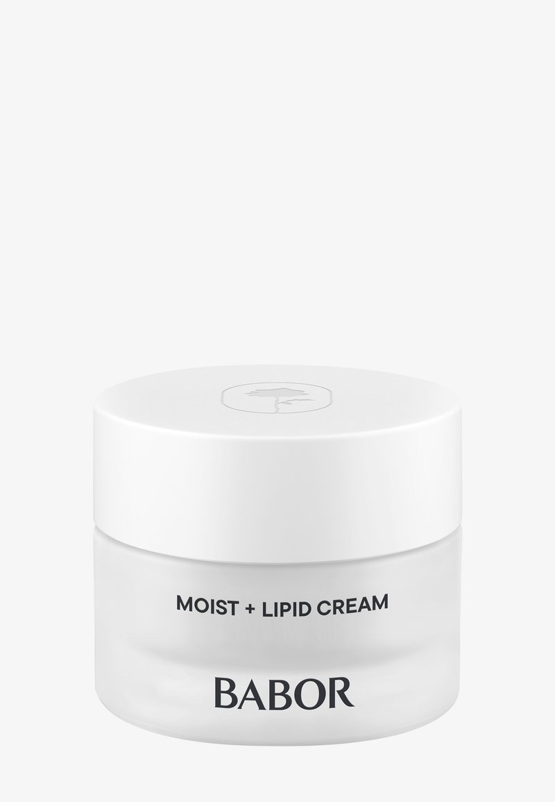 El tarro de crema hidratante y lipídica tiene una base de vidrio transparente y una tapa blanca suave, con texto minimalista en negro; tiene forma redonda con un acabado pulido.
