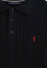 Svart stickad polo med kabelmönster, med en tvåknapps placket och en liten röd broderad figurlogo på bröstet.