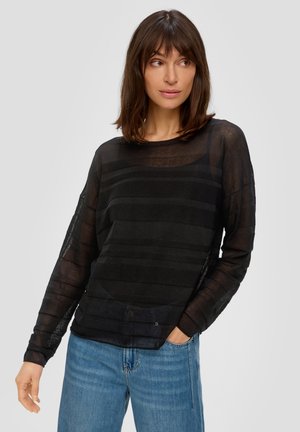 Top nero a maniche lunghe con tessuto traslucido e texturizzato caratterizzato da strisce orizzontali. Girocollo e vestibilità rilassata, abbinato a jeans in denim blu chiaro.
