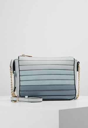 Petit sac bandoulière rectangulaire avec des rayures horizontales en dégradé de nuances de bleu, doté d'une chaîne dorée et d'une sangle ajustable.