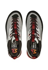 Un paio di scarpe atletiche grigie e nere con accenti rossi e lacci neri, viste dall'alto, che mostrano le solette con il marchio.