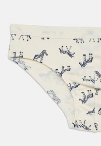 Kinderunterwäsche aus Crepe mit schwarzen Zebra-Mustern und elastischem Bund, Nahaufnahme, die den Stoff und die Nähdetails zeigt.