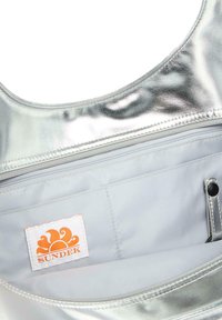 Borsa metallic silver con una texture liscia, dotata di un interno grigio chiaro e una tasca con zip, include un'etichetta del logo orange SUNDEK.