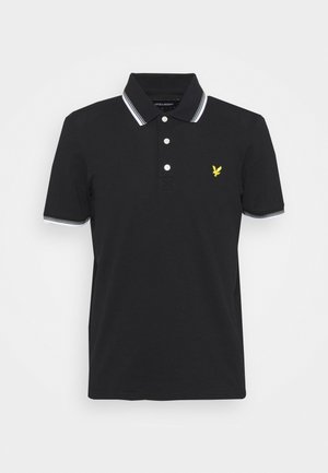 Zwarte polo-shirt van katoen. Heeft een placket met twee knopen, een kraag en mouwen met witte strepen, en een gele geborduurde logo op de borst.