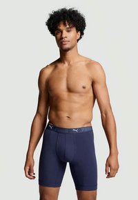Marineblå boxer shorts laget av myk fabric, med en glatt linning som har Puma-logoen, designet for komfort og passform.