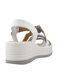 Sandali con zeppa bianchi con cinturini incrociati, soletta imbottita e suola grigia texture, che uniscono materiali lisci e metallici.