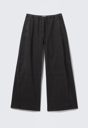 Pantalons larges noirs en coton. Présentent une taille élastique et des coutures latérales avec des détails de couture. Devant plat sans poches.