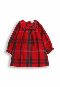 Czerwona sukienka w kratę z długimi bufkami na rękawach, marszczonym gorsetem i kokardą z przodu. Materiał ozdobiony jest dużymi wzorami krat w kolorze czerwonym i zielonym.