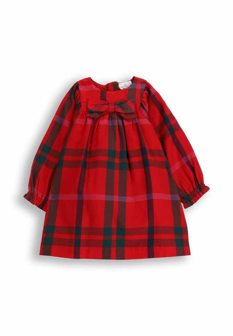Czerwona sukienka w kratę z długimi bufkami na rękawach, marszczonym gorsetem i kokardą z przodu. Materiał ozdobiony jest dużymi wzorami krat w kolorze czerwonym i zielonym.