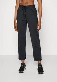 Czarne spodnie dresowe wykonane z miękkiego materiału, z elastycznym pasem i sznurkiem do regulacji oraz logo Nike na lewej udzie.