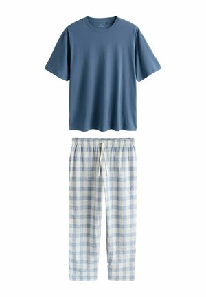 Sinine lühikeste varrukatega ümara kaelusega särk, mida kannab koos helesiniste ja valgete ruuduliste paelaga pidžaamapükstega.